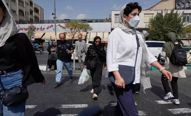 FILE - People cross the Enqelab-e-Eslami (Islamic Revolution) street in Tehran, Iran, on Sept. 27, 2025. (AP Photo/Vahid Salemi, File)