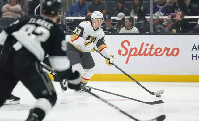 Vegas Golden Knights left wing Cole Reinhardt (23) looks to take a shot on goal as Los Angeles Kings defenseman Brandt Clarke (92) defends during the first period of an NHL hockey game Wednesday, Jan. 14, 2026, in Los Angeles. (AP Photo/Caroline Brehman)