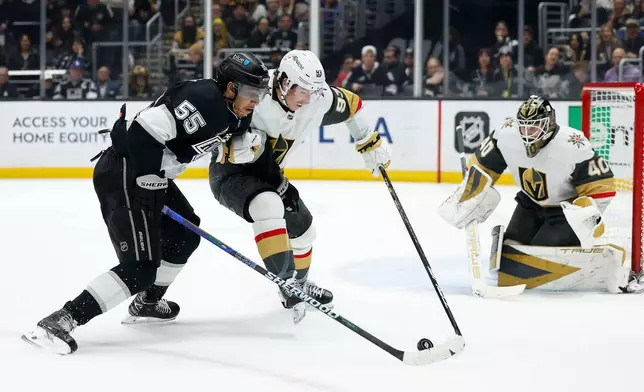 Los Angeles Kings right wing Quinton Byfield (55) and Vegas Golden Knights right wing Mitch Marner (93) fight for possession of the puck during the second period of an NHL hockey game Wednesday, Jan. 14, 2026, in Los Angeles. (AP Photo/Caroline Brehman)