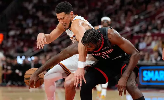 Houston Rockets' Tari Eason (17) knocks the ball away from Phoenix Suns' Devin Booker during the first half of an NBA basketball game Monday, Jan. 5, 2026, in Houston. (AP Photo/David J. Phillip)