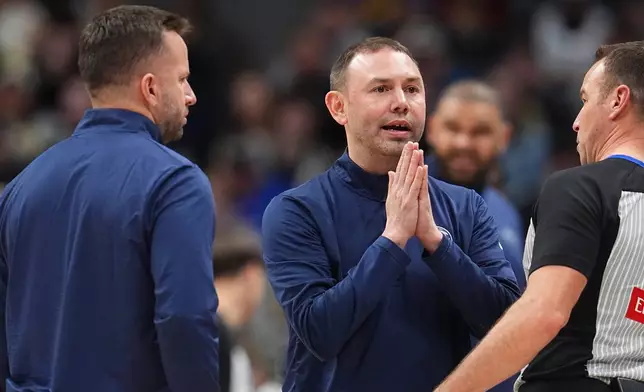 Denver Nuggets head coach David Adelman, center, confers with referee Josh Tiven, right, as assistant coach JJ Berea looks on in the second half of an NBA basketball game against the Charlotte Hornets Sunday, Jan. 18, 2026, in Denver. (AP Photo/David Zalubowski)
