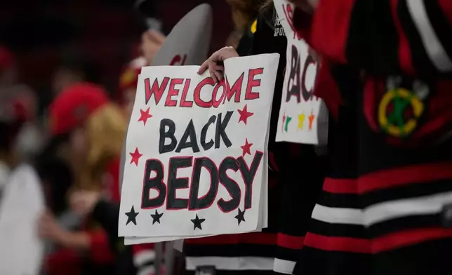 Hockey fans hold a sign as Chicago Blackhawks center Connor Bedard warms up before an NHL hockey game against the Washington Capitals, Friday, Jan. 9, 2026, in Chicago. (AP Photo/Erin Hooley)