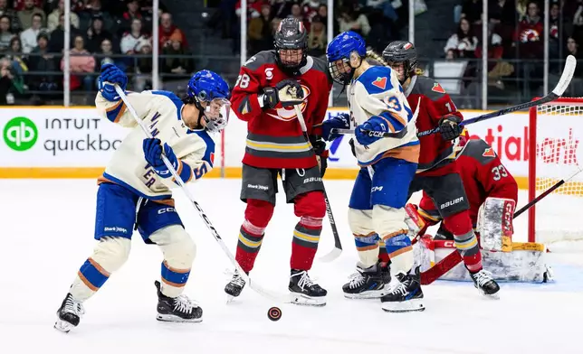Ottawa Charge's Ronja Savolainen (88) and Vancouver Goldeneyes' Tereza Vanisova (13) track the puck as Goldeneyes' Anna Segedi (51) tries to maintain possession during the second period of an PWHL hockey game in Ottawa, Friday, Jan. 9, 2026. (Spencer Colby/The Canadian Press via AP)