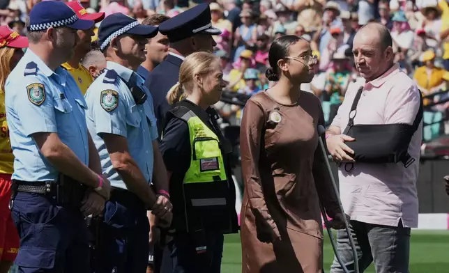 First responders and survivors from the Bondi Beach shooting arrive onto the field during a ceremony ahead play on day one of the fifth and final Ashes cricket test between England and Australia in Sydney, Sunday, Jan. 4, 2026. (AP Photo/Mark Baker)