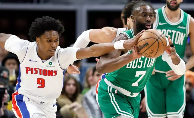 Detroit Pistons guard Ausar Thompson (9) knocks the ball away from Boston Celtics guard Jaylen Brown (7) during the first half of an NBA basketball game Monday, Jan. 19, 2026, in Detroit. (AP Photo/Duane Burleson)