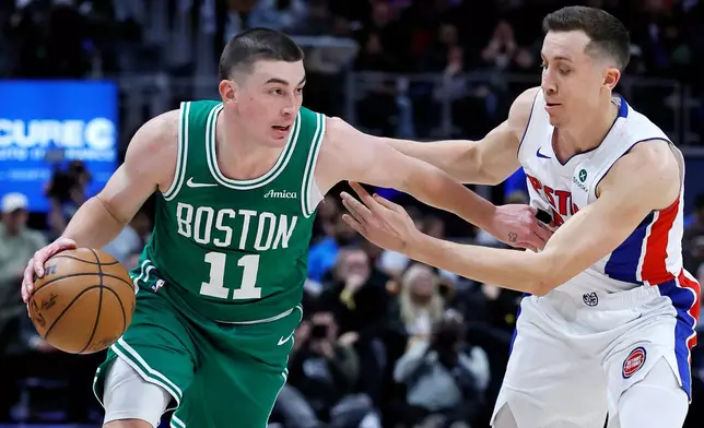 Boston Celtics guard Payton Pritchard (11) drives against Detroit Pistons forward Duncan Robinson during the first half of an NBA basketball game Monday, Jan. 19, 2026, in Detroit. (AP Photo/Duane Burleson)