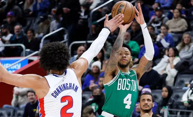Boston Celtics guard Anfernee Simons (4) takes a shot against Detroit Pistons guard Cade Cunningham (2) during the first half of an NBA basketball game Monday, Jan. 19, 2026, in Detroit. (AP Photo/Duane Burleson)