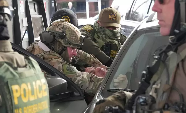 U.S. Border Patrol agents remove a person from their vehicle, Sunday, Jan. 11, 2026, in St. Paul, Minn. (AP Photo/Adam Gray)