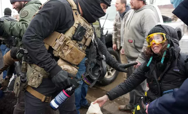 Federal agents detain a person on Wednesday, Jan. 21, 2026, in Minneapolis. (AP Photo/Angelina Katsanis)