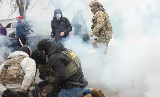 Tear gas is deployed as Federal agents make arrests on Wednesday, Jan. 21, 2026, in Minneapolis. (AP Photo/Angelina Katsanis)