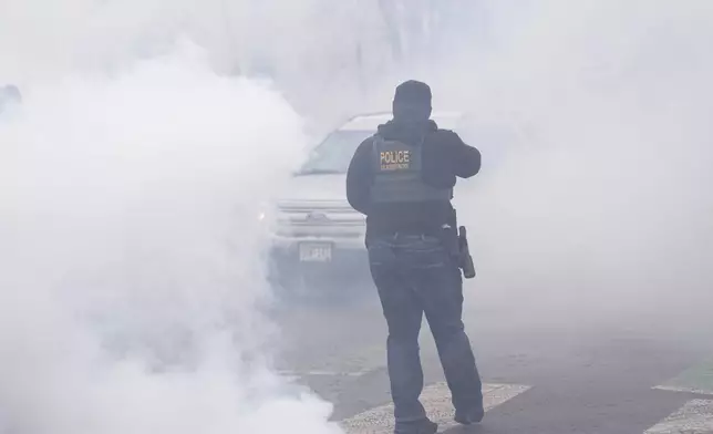 Tear gas is deployed as Federal agents make arrests on Wednesday, Jan. 21, 2026, in Minneapolis. (AP Photo/Angelina Katsanis)