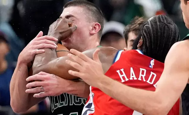 Boston Celtics guard Payton Pritchard, left, is hit in the face by Los Angeles Clippers guard James Harden as Harden drives toward the basket during the first half of an NBA basketball game Saturday, Jan. 3, 2026, in Inglewood, Calif. (AP Photo/Mark J. Terrill)