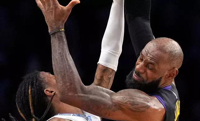 Memphis Grizzlies guard Ja Morant, left, and Los Angeles Lakers forward LeBron James go after a rebound during the second half of an NBA basketball game Friday, Jan. 2, 2026, in Los Angeles. (AP Photo/Mark J. Terrill)