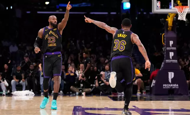 Los Angeles Lakers forward LeBron James, left, and guard Marcus Smart celebrate after Smart scored during the second half of an NBA basketball game against the Memphis Grizzlies, Friday, Jan. 2, 2026, in Los Angeles. (AP Photo/Mark J. Terrill)