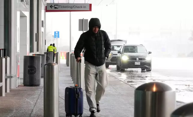A man arrives at Love Field Airport for a scheduled flight to San Mateo, California that had not yet been cancelled Saturday, Jan. 24, 2026, in Dallas. (AP Photo/Tony Gutierrez)
