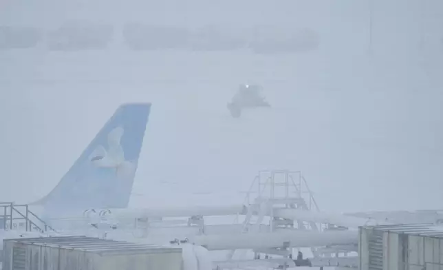 Airport crew plow snow during a winter storm in Philadelphia, Sunday, Jan. 25, 2026. (AP Photo/Matt Rourke)