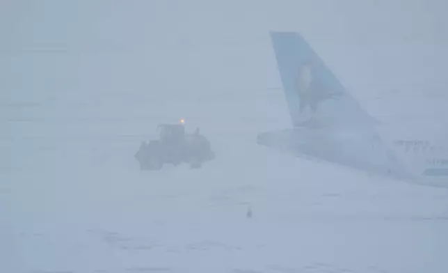 Airport crew plow snow during a winter storm in Philadelphia, Sunday, Jan. 25, 2026. (AP Photo/Matt Rourke)