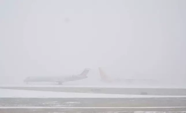 Planes move on the tarmac at the Nashville International Airport during a winter storm Saturday, Jan. 24, 2026, in Nashville, Tenn. (AP Photo/George Walker IV)