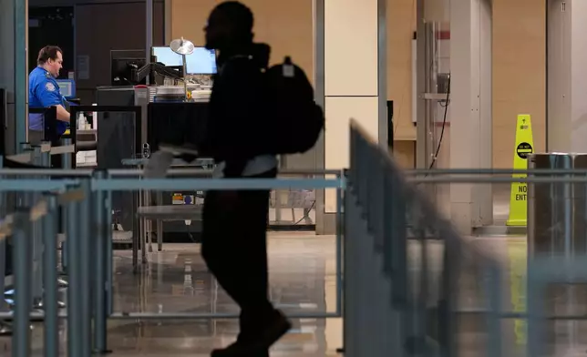 A lone traveler approaches a TSA checkpoint at Love Field Airport Saturday, Jan. 24, 2026, in Dallas. (AP Photo/Tony Gutierrez)