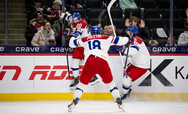 Czechia's Adam Benak celebrates his goal with teammates Tomas Poletin (18) and Radim Mrtka during the second period of an IIHF World Junior Hockey Championship semifinals game, Sunday, Jan. 4, 2026, in St. Paul, Minn. (Christopher Katsarov/The Canadian Press via AP)