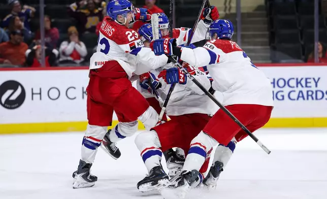 Czechia forward Tomas Poletin (18) celebrates his go ahead goal with teammates during the third period of an IIHF World Junior Hockey Championship semifinals game against Canada, Sunday, Jan. 4, 2026, in St. Paul, Minn. (AP Photo/Matt Krohn)