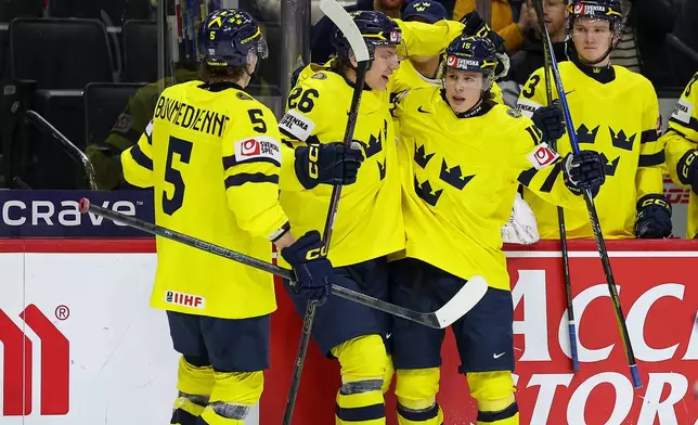Sweden forward Ivar Stenberg, right, celebrates his goal with teammates during the second period of an IIHF World Junior Hockey Championship semifinals game against Finland, Sunday, Jan. 4, 2026, in St. Paul, Minn. (AP Photo/Matt Krohn)