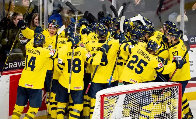 Team Sweden players celebrate after Anton Frondell scored on Finland goaltender Petteri Rimpinen (30) during overtime shoot-out in an IIHF World Junior Hockey Championship semifinals game in St. Paul, Minn., Sunday, Jan. 4, 2026. (Christopher Katsarov/The Canadian Press via AP)