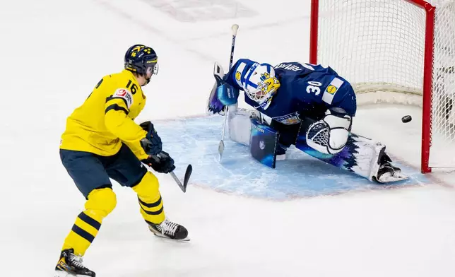 Sweden's Anton Frondell (16) scores on Finland goaltender Petteri Rimpinen during overtime shoot-out in an IIHF World Junior Hockey Championship semifinals game in St. Paul, Minn., Sunday, Jan. 4, 2026. (Christopher Katsarov/The Canadian Press via AP)