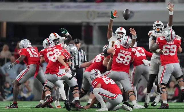 Ohio State kicker Jayden Fielding, with Joe McGuire holding, misses a field goal against Miami during the first half of the Cotton Bowl College Football Playoff quarterfinal game Wednesday, Dec. 31, 2025, in Arlington, Texas. (AP Photo/Julio Cortez)