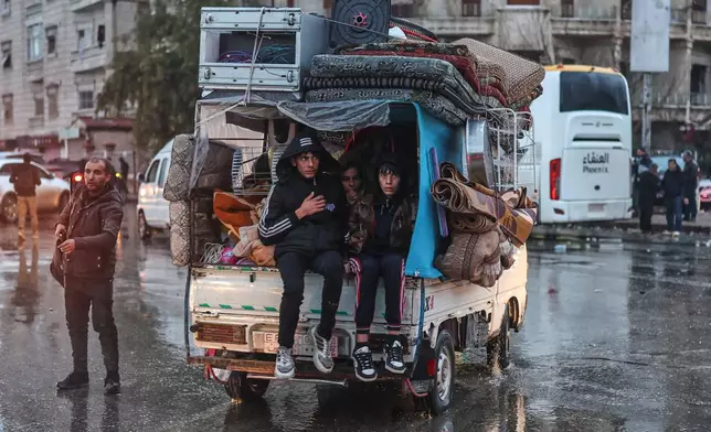 Residents flee the Sheikh Maqsoud neighborhood of Aleppo, Syria, Friday, Jan. 9, 2026, after the government declared the area a closed military zone following days of clashes between government forces and Kurdish fighters. (AP Photo/Ghaith Alsayed)