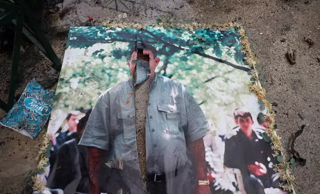 A defaced picture of Abdullah Ocalan, the imprisoned leader of the Kurdistan Workers' Party, or PKK, lies on the floor in the predominantly Kurdish Sheikh Maqsoud neighborhood in the northern city of Aleppo, Syria, Monday, Jan. 12, 2026, where clashes broke out on Jan. 6, between government forces and the Kurdish-led Syrian Democratic Forces. (AP Photo/Omar Albam)