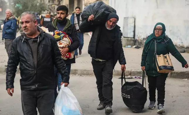 Residents flee the Sheikh Maqsoud and Achrafieh neighbourhoods after clashes erupted Tuesday between Syrian government forces and Kurdish fighters in a contested area of the northern city of Aleppo, Syria, Thursday, Jan. 8, 2026. (AP Photo/Ghaith Alsayed)