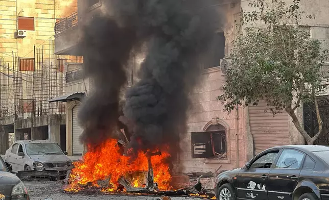A car burns during clashes between Kurdish fighters and Syrian government forces in a contested area of the northern city of Aleppo, Syria, Wednesday, Jan. 7, 2026. (AP Photo/Omar Albam)