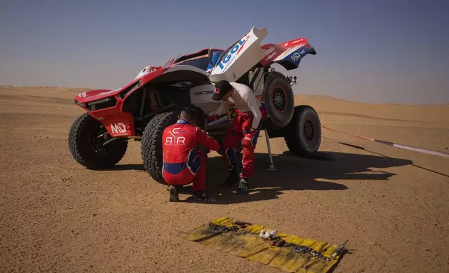 Driver Simon Vitse and co-driver Max Delfino check their car at the end of the ninth stage of the Dakar Rally between Wadi Ad Dawasir and Bisha, Saudi Arabia, Tuesday, Jan.13, 2026. (AP Photo/Thibault Camus)