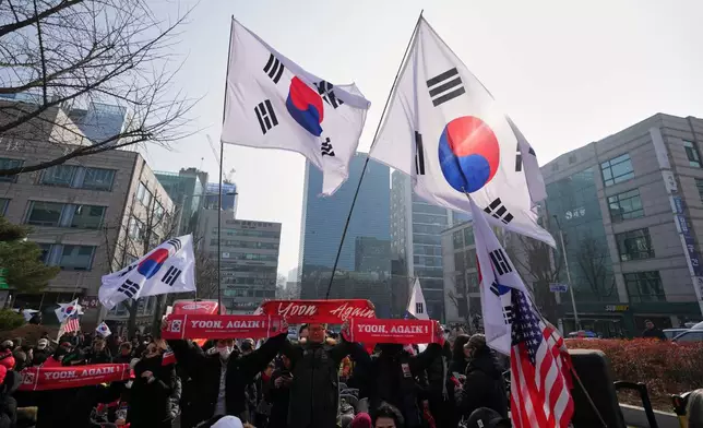 Supporters of former South Korean President Yoon Suk Yeol hold signs and flags outside Seoul Central District Court, in Seoul, South Korea, Friday, Jan. 16, 2026. (AP Photo/Lee Jin-man)