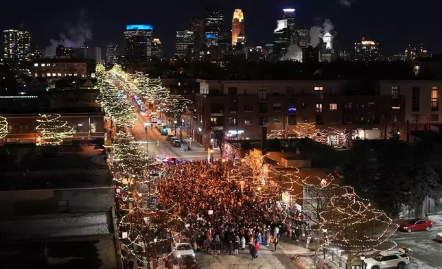 People gather during a vigil where Alex Pretti was shot and killed by federal immigration enforcement in Minneapolis, on Wednesday, Jan. 28, 2026. (AP Photo/Adam Gray)
