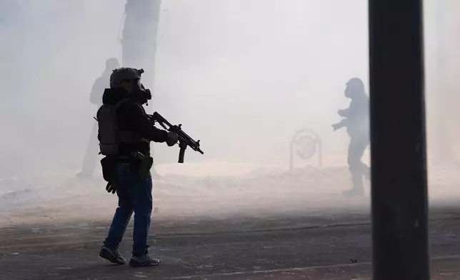Federal immigration officers deploy tear gas after a shooting in Minneapolis, on Saturday, Jan. 24, 2026. (AP Photo/Abbie Parr)