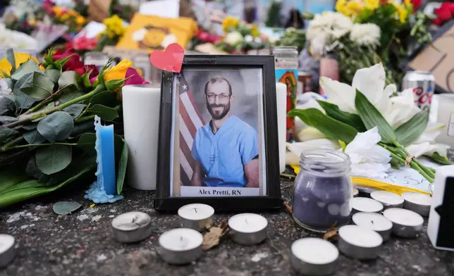 A photo of 37-year-old Alex Pretti, who was fatally shot by a U.S. Border Patrol officer over the weekend, is displayed at the shooting scene Monday, Jan. 26, 2026, in Minneapolis. (AP Photo/Adam Gray)