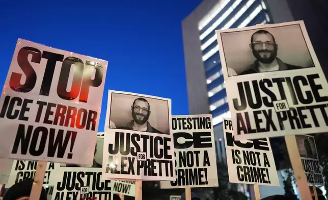 Demonstrators hold signs during a rally against federal immigration enforcement at Federal Courthouse Plaza on Tuesday, Jan. 27, 2026, in Minneapolis. (AP Photo/Adam Gray)