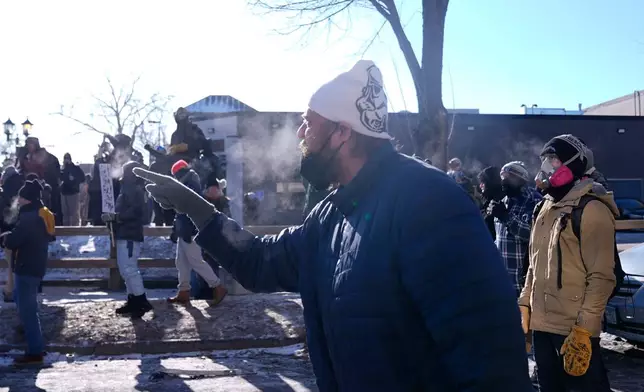 A person yells at federal immigration officers, Saturday, Jan. 24, 2026, in Minneapolis. (AP Photo/Abbie Parr)
