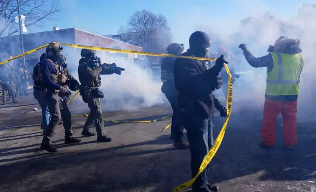 Federal immigration officers deploy tear gas at protesters after a shooting Saturday, Jan. 24, 2026, in Minneapolis. (AP Photo/Abbie Parr)