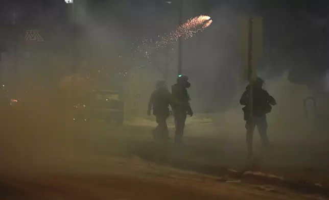 Flares are seen as federal agents try to clear the demonstrators near a hotel, using tear gas during a noise demonstration protest in response to federal immigration enforcement operations in the city Sunday, Jan. 25, 2026, in Minneapolis. (AP Photo/Adam Gray)