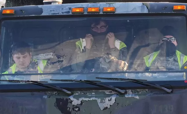 Minnesota National Guard members sit inside their vehicle outside the Bishop Henry Whipple Federal Building, Sunday, Jan. 25, 2026, in Minneapolis. (AP Photo/Adam Gray)