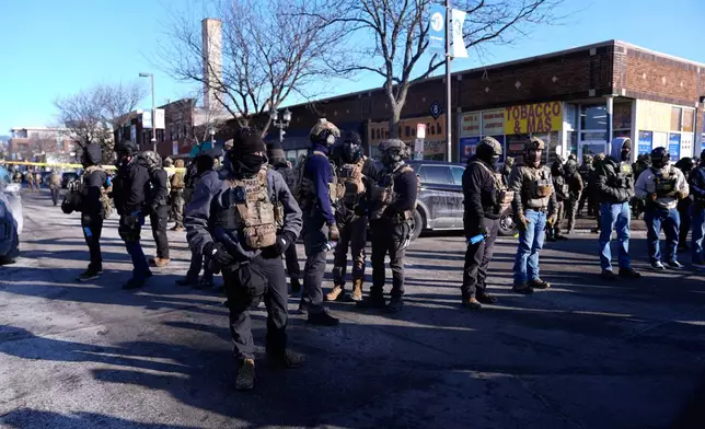 Federal agents stand near the site of a shooting Saturday, Jan. 24, 2026, in Minneapolis. (AP Photo/Abbie Parr)