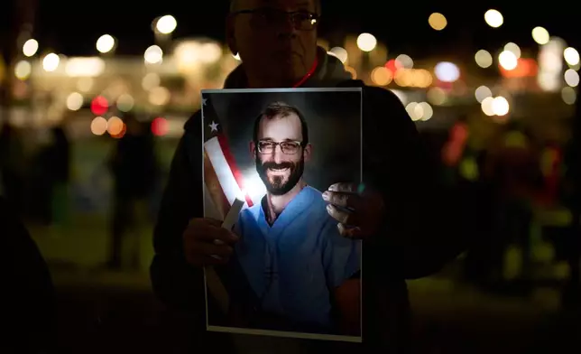 A person holds a picture during a vigil for Alex Pretti, who was shot and killed by federal immigration enforcement in Minneapolis, Wednesday, Jan. 28, 2026, in Henderson, Nev. (AP Photo/John Locher)