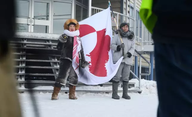 Iqaluit residents, Laakkuluk Williamson Bathory and Siku Rojas hold a Greenlandic banner during a solidarity march through Nunavut's capital, on Saturday, Jan. 17, 2026. (Dustin Patar/The Canadian Press via AP)