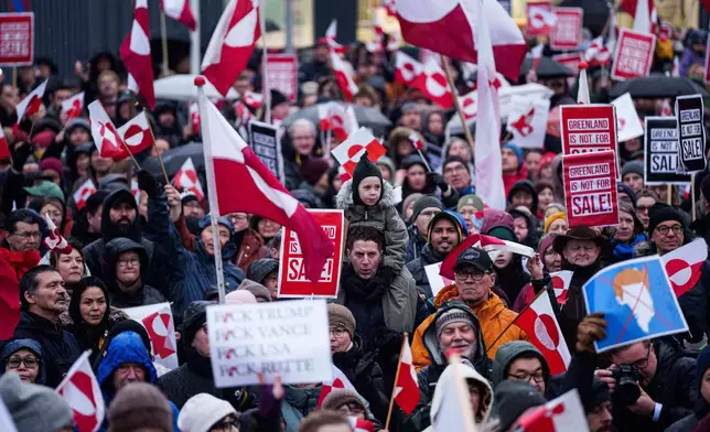 EDS NOTE: OBSCENITY - A crowd walks to the US consulate to protest against Trump's policy towards Greenland in Nuuk, Greenland, Saturday, Jan. 17, 2026. (AP Photo/Evgeniy Maloletka)
