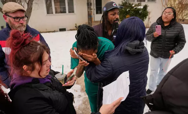 A family member, center, reacts after federal immigration officers make an arrest Sunday, Jan. 11, 2026, in Minneapolis. (AP Photo/John Locher)