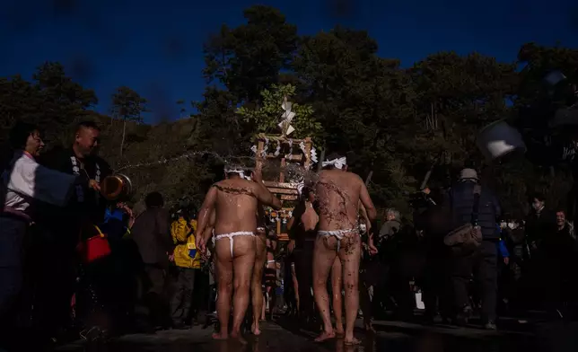 Participants carry a portable shrine 'mikoshi', during the Winter Sea Misogi Festival, a Shinto purification ritual marking the New Year, in Numazu, Japan, Monday, Jan. 12, 2026. (AP Photo/Louise Delmotte)