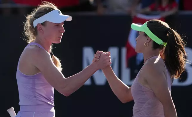 Zeynep Sonmez, right, of Turkey is congratulated by Ekaterina Alexandrova of Russia following their first round match at the Australian Open tennis championship in Melbourne, Australia, Sunday, Jan. 18, 2026. (AP Photo/Asanka Brendon Ratnayake)
